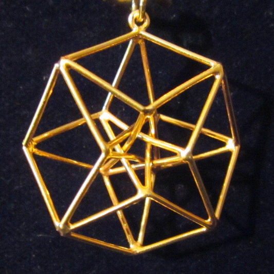 May include: A gold-coloured geometric pendant necklace. The pendant has a complex, three-dimensional design of interconnected lines forming a multifaceted shape. The necklace hangs against a dark background.
